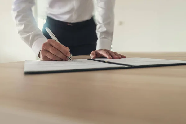 Geschäftsmann Der Seinem Schreibtisch Steht Und Urkunden Oder Verträge Unterschreibt — Stockfoto