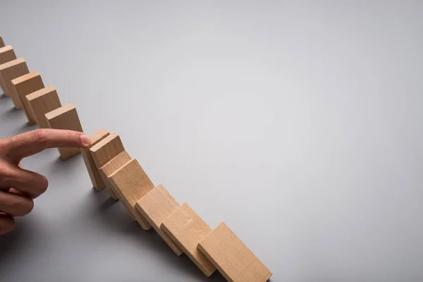 Zakenman Stoppen Domino Effect Met Zijn Vinger Grijze Achtergrond Met — Stockfoto