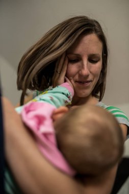 Genç Anne sevgi dolu ifade şefkatle kucak yüzü ufak küçük el ile dokunmak bebeğini holding ile.