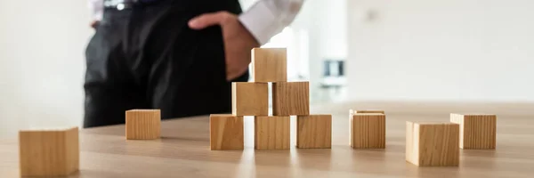 Wooden Cubes Stacked Pyramid Office Desk Businessman Standing Background — Stock Photo, Image