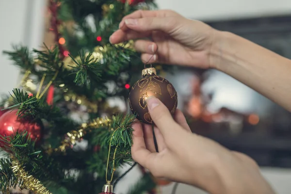 Close Van Vrouwelijke Handen Opknoping Van Een Bruin Vakantie Bauble — Stockfoto