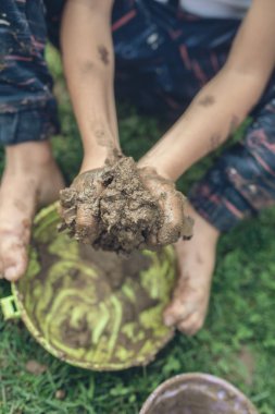 Çimenlerin üzerinde oturur gibi çamur ve tencere ile oynarken doğa keşfetmek yürümeye başlayan çocuk Retro imajının. Üstten görünüm.