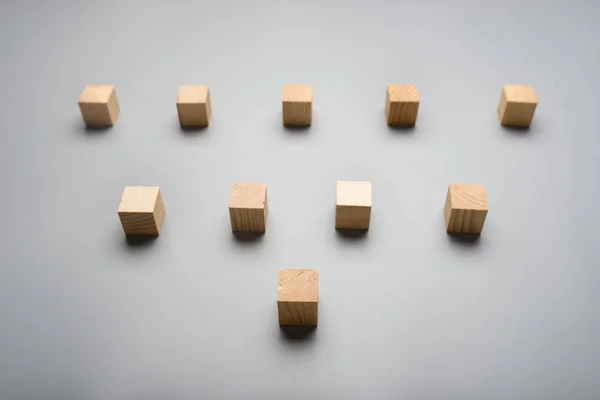 Deset Prázdné Dřevěné Kostky Umístěné Nad Šedým Pozadím Tvaru Trojúhelníku — Stock fotografie