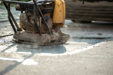 Yolun önemli bir yama için yeni asfalt döşeme son aşamasında bitirme kompaktör.