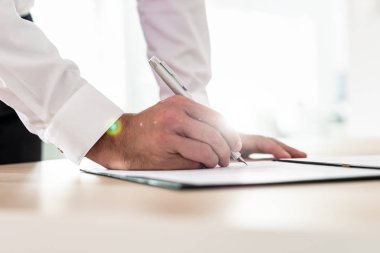 Sözleşme veya uygulamanın formu office masasına yaslanmış imzalama işadamı.