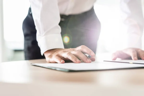 Empresário Sua Mesa Escritório Inclinando Para Assinar Documento Segurando Uma — Fotografia de Stock