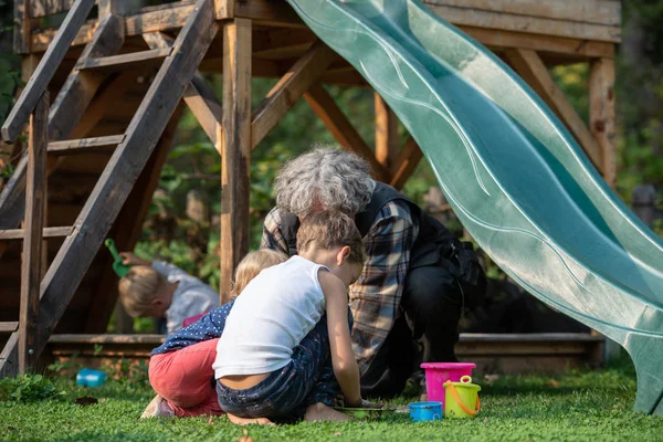 Tre Bambini Che Giocano Con Nonno Fuori Cortile Divertendosi — Foto Stock