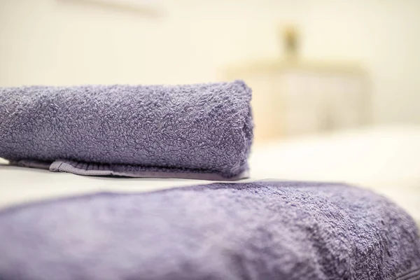 在按摩床上卷起并准备好的紫色毛巾的低角度视图 — 图库照片