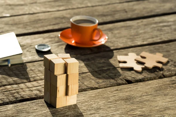 素朴な木の机に置かれたビジネス戦略とスタートアップのコンセプト コーヒー カップ コンパス 木製のブロック パズルのピース — ストック写真