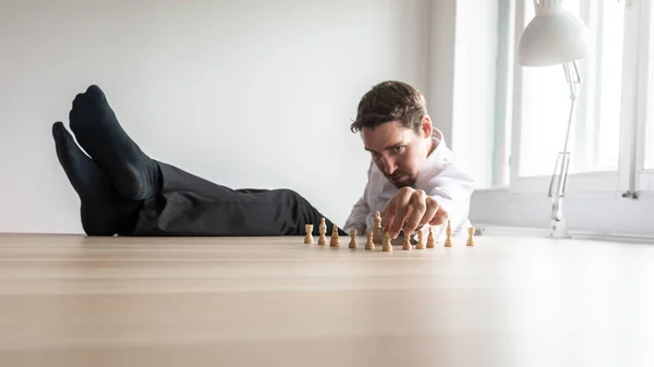 若いビジネス リーダー座ってリラックス両足を組織構造でのチェスの駒の配置彼のオフィスの机の上 — ストック写真