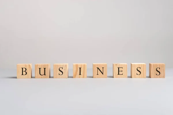 灰色の背景の上のビジネスをスペルの文字と 木製ブロック コピー スペース — ストック写真