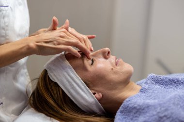 Profil görünümü ve cilt bakım tedavi gençleştirici yüz masajı zevk genç kadın.