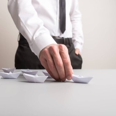 İş lideri filo kağıt önde gelen tekne tutan origami tekneler kavramsal bir görüntüde yaptı..