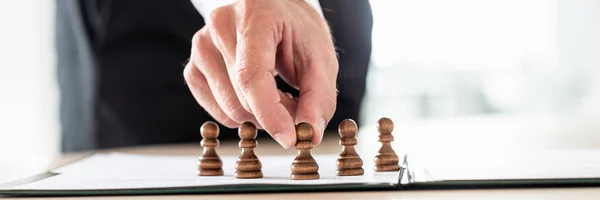 Human resources and recruiting concept - business employer positioning chess pawn pieces on a contract.