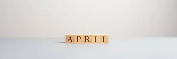 Großansicht von fünf Holzklötzen, die das Wort April buchstabieren — Stockfoto