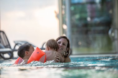 Yüzme havuzunda zevk iki çocuklu genç anne