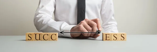 Businessman connecting two sides of wooden blocks to spell the w — Stock Photo, Image