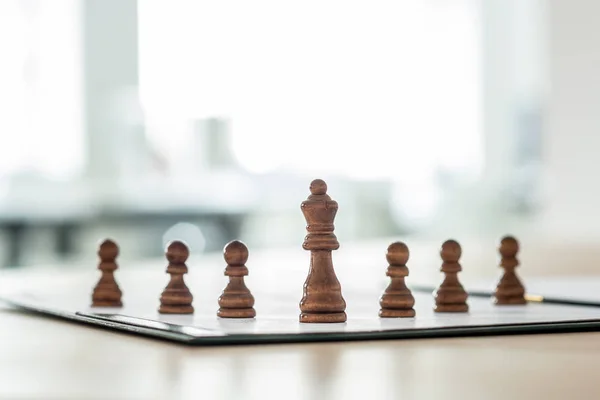 Chess pieces of king and six pawns placed on a document — Stock Photo, Image