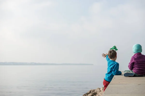Two toddler boys sitting on a pier — Stock Photo, Image