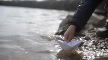 Toddler çocuk oyun ile Origami Tekne yakın nehir