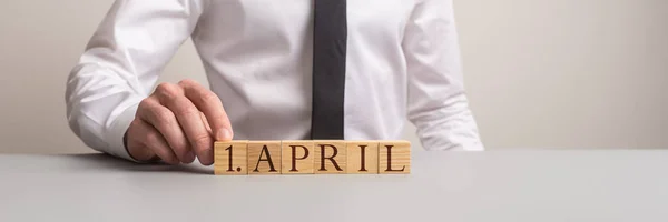 Wide view image of a man assembling an 1.April sign — Stock Photo, Image