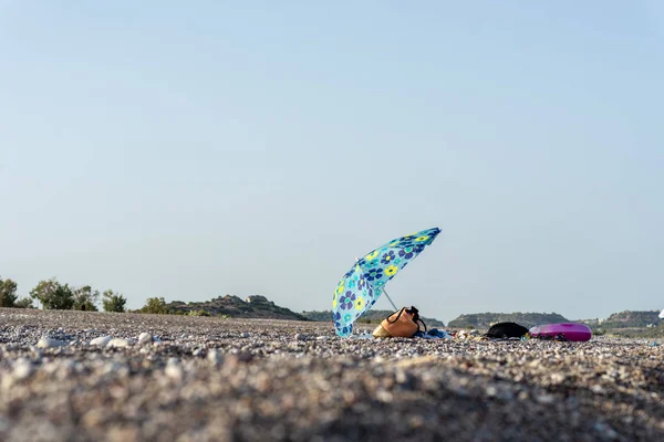 Plážový sáček a ručníky pod sluncem slunečníkem na pláži — Stock fotografie
