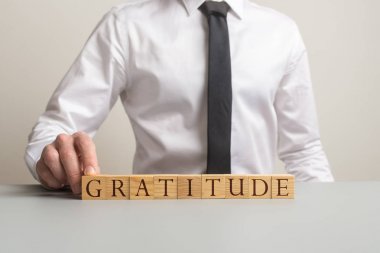 İşadamı masasında oturmuş Şükran işareti topluyor