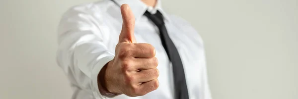 Businessman showing a thumbs up sign toward the camera — Stock Photo, Image