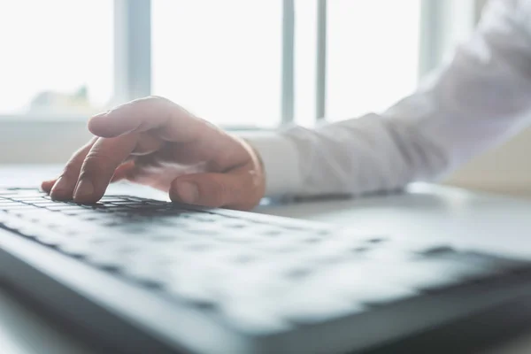 Immagine luminosa di un uomo d'affari che digita sulla tastiera del computer — Foto Stock