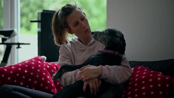 Ung kvinna kramas och leker med sin svarta hund — Stockvideo