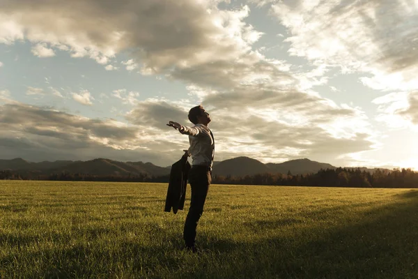 Businessman standing in nature with arms wide open — Stock Photo, Image