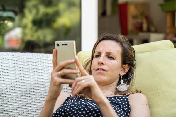 Young woman browsing on her mobile phone — Stock Photo, Image