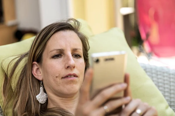 Mujer joven mirando su teléfono móvil — Foto de Stock