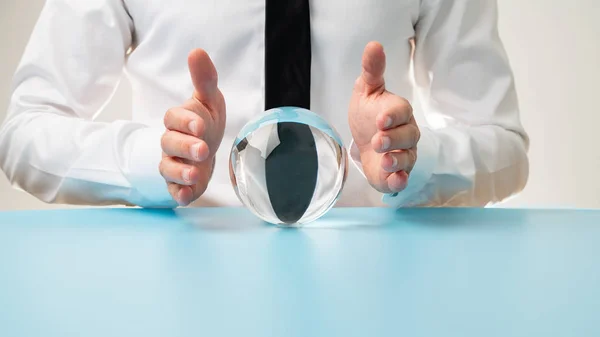 Businessman holding protective hands over a crystal ball — Stock Photo, Image