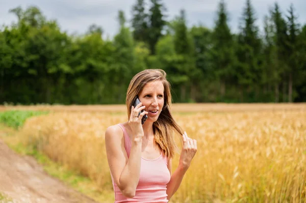 Jovem mulher andando na natureza falando no telefone celular — Fotografia de Stock