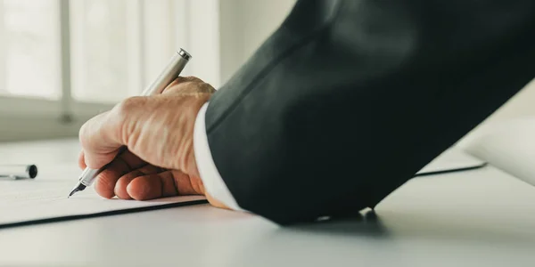 Geschäftsmann unterschreibt Vertrag auf seinem Schreibtisch — Stockfoto