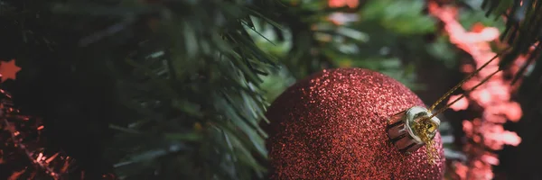 Röd julkula hängande på dekorerad träd — Stockfoto