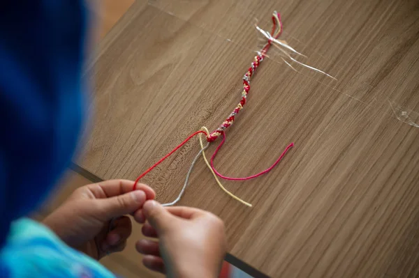Child braiding a necklace — Stock Photo, Image