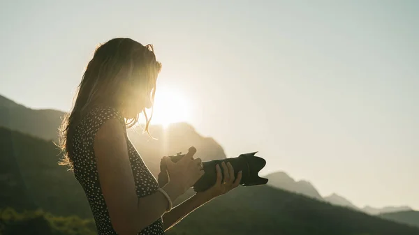 Young female photographer looking at her dslr camera — Stock Photo, Image