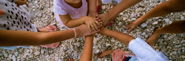 Seis niños apilando sus pequeñas manos — Foto de Stock