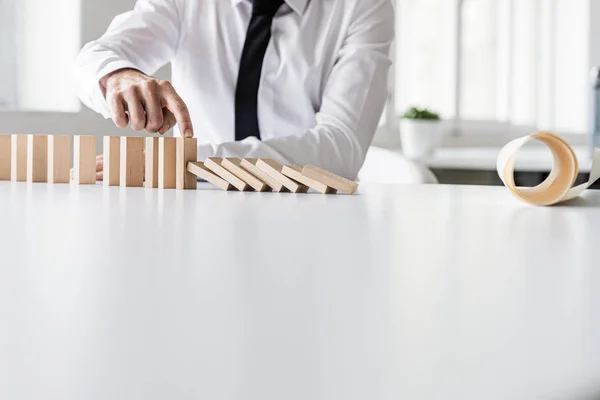 Business crisis manager stopping dominos from collapsing — Stock Photo, Image