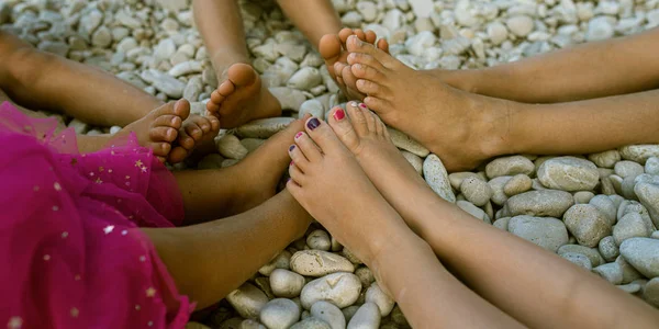 Children feet on pebble beach — Stock Photo, Image