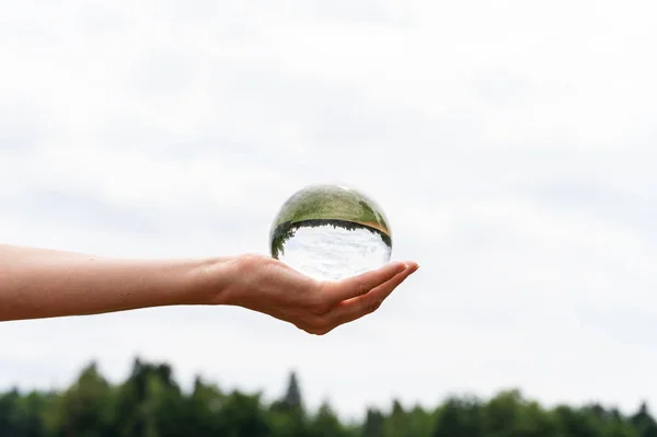 Mano femenina sosteniendo una esfera de cristal —  Fotos de Stock