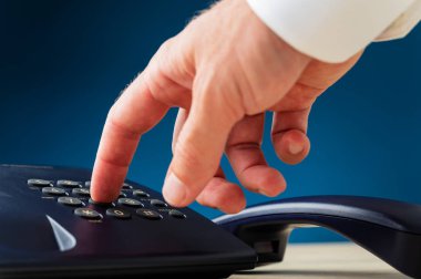 Telefon numarasını çeviren erkek elin yakın çekim görünümü