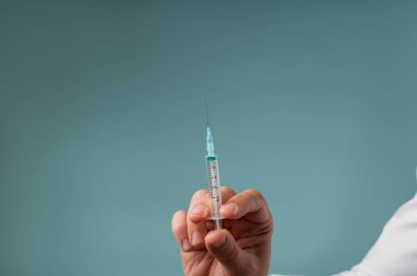 Doktor iğneyle iğne tutar.
