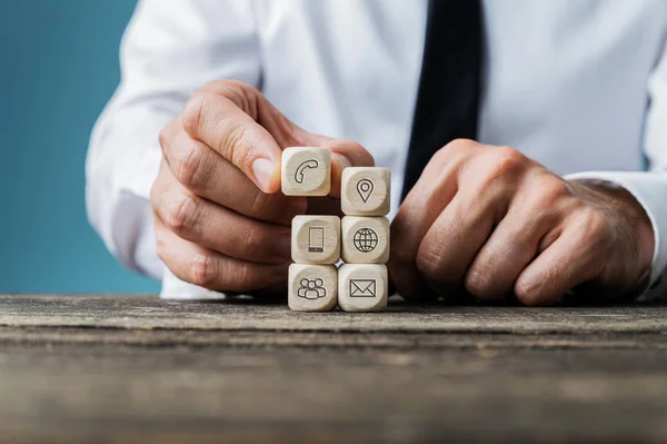 Apilar los dados de madera con los iconos de contacto e información en ellos — Foto de Stock