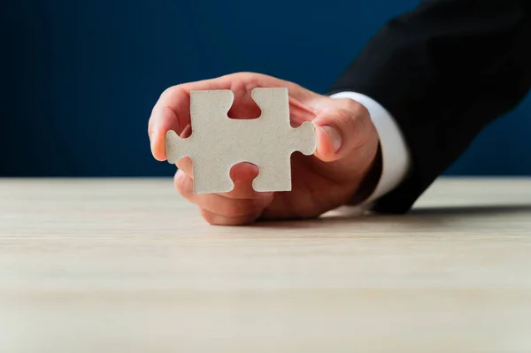 Businessman holding blank puzzle piece — ストック写真