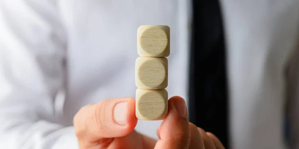 Businessman holding three stacked blank wooden dices — Stock Photo, Image