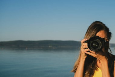 Genç bayan fotoğrafçı doğrudan size fotoğraf çekiyor.
