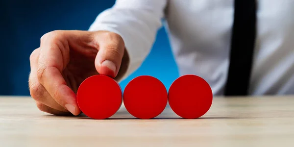 Colocando três círculos de madeira vermelha em branco em uma fileira — Fotografia de Stock